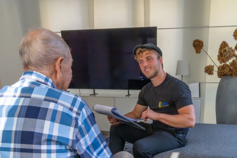 Ein Mitarbeiter von John & Martin bespricht im Wohnzimmer mit einem Kunden, was umzieht.